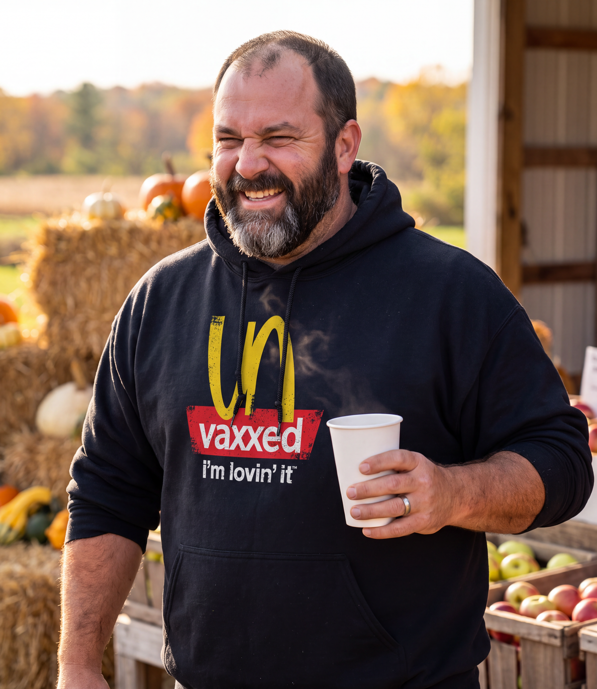Man wearing the black Unvaxxed Hoodie at a fall farm stand