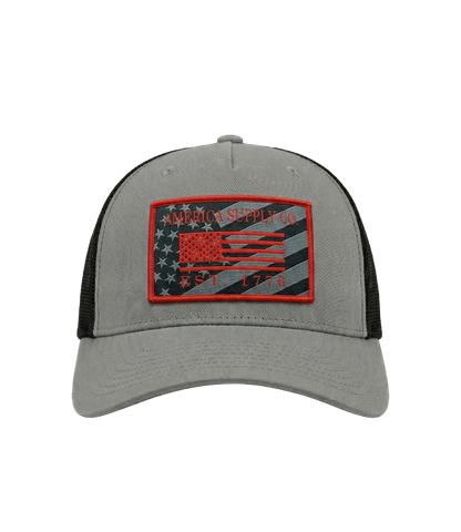 The Alex Jones Store - Front view of grey America Supply Co patch trucker hat with red-bordered American flag Est. 1776 woven patch