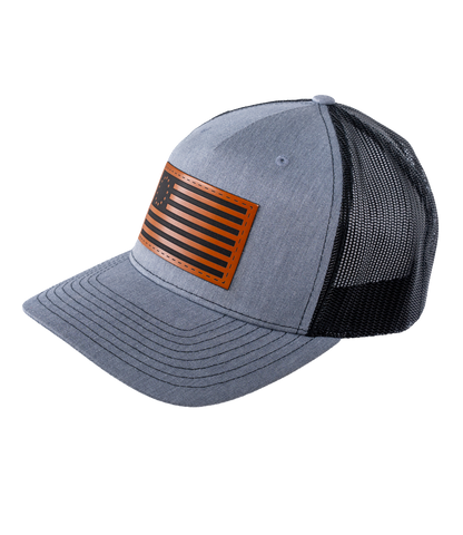 The Alex Jones Store - Three-quarter view of heather grey Betsy Ross American Flag leather patch trucker hat with black mesh back panel