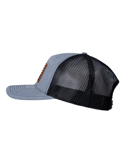 The Alex Jones Store - Heather grey and black trucker hat, left side view, with American flag leather patch on front, Betsy Ross flag style