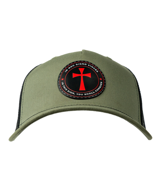 The Alex Jones Store - Front of olive green trucker hat with circular patch showing red cross and 'In Hoc Signo Vinces - In This Sign You Shall Conquer'