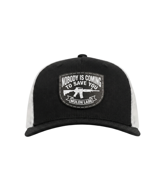 The Alex Jones Store - Front of black and white Nobody Is Coming To Save You trucker hat with stitched Molon Labe rifle patch on black front panel and white mesh back